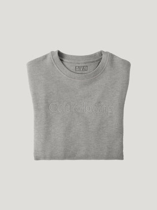 Folded gray t-shirt with 'Cult Following' text on a light gray background